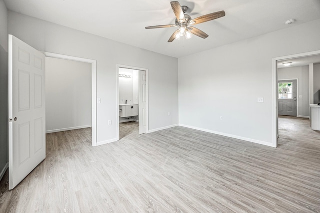 unfurnished bedroom featuring light wood finished floors, ensuite bath, and a ceiling fan