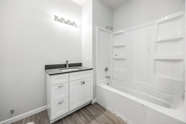 bathroom with wood finished floors, vanity, and shower / bathtub combination