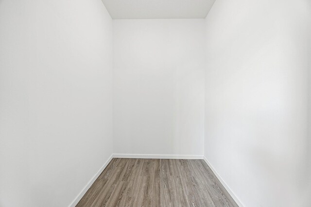 spare room featuring wood finished floors and baseboards