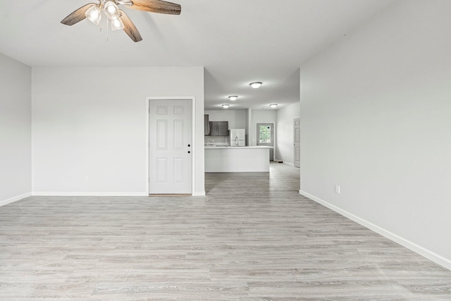 unfurnished living room featuring a ceiling fan and light wood-style flooring