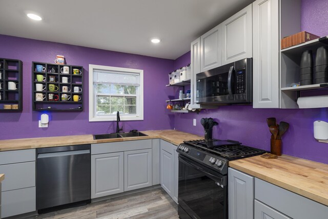2080 State Route 14, West Plains, MO 65775 - kitchen with stainless steel dishwasher, open shelves, gas stove, wooden counters, and light wood-type flooring