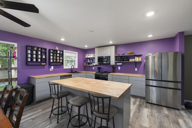 2080 State Route 14, West Plains, MO 65775 - kitchen with wooden counters, stainless steel appliances, open shelves, wood finished floors, and a breakfast bar