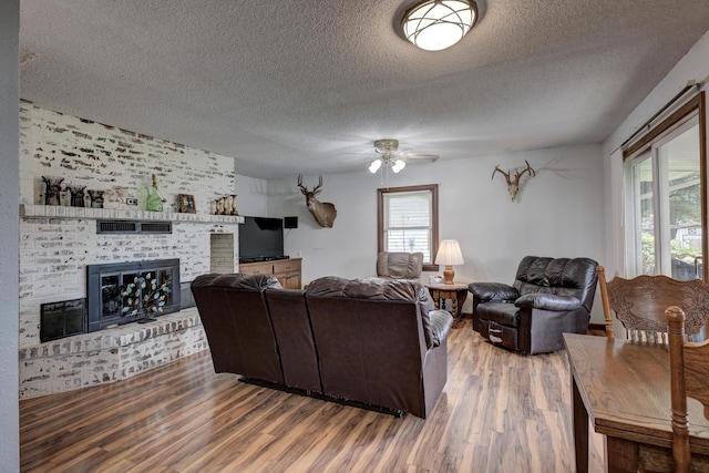 2148 Carrie St, Carthage, MO 64836 - living room featuring a textured ceiling, wood finished floors, a fireplace, and ceiling fan