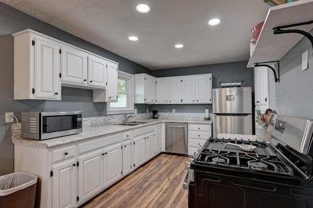 2148 Carrie St, Carthage, MO 64836 - kitchen with appliances with stainless steel finishes, light wood-type flooring, recessed lighting, white cabinets, and light stone counters