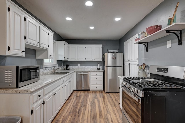 2148 Carrie St, Carthage, MO 64836 - kitchen featuring stainless steel appliances, open shelves, light wood-type flooring, white cabinetry, and recessed lighting
