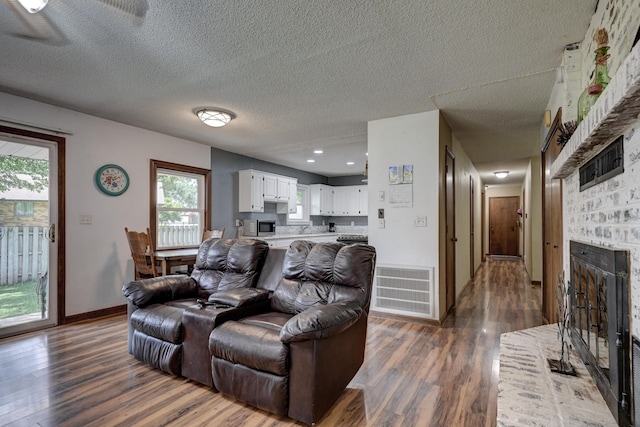 2148 Carrie St, Carthage, MO 64836 - living area featuring a fireplace, dark wood finished floors, and a textured ceiling