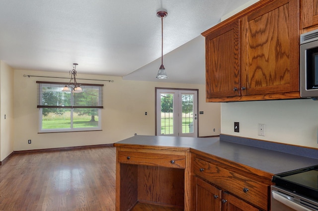 14521 Lawrence Unit 2145, Mount Vernon, MO 65712 - kitchen with a peninsula, brown cabinets, stainless steel microwave, wood finished floors, and pendant lighting