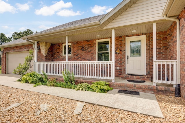 14521 Lawrence Unit 2145, Mount Vernon, MO 65712 - property entrance with covered porch, an attached garage, brick siding, concrete driveway, and roof with shingles