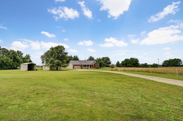 14521 Lawrence Unit 2145, Mount Vernon, MO 65712 - view of green lawn featuring driveway, a garage, a rural view, and an outdoor structure