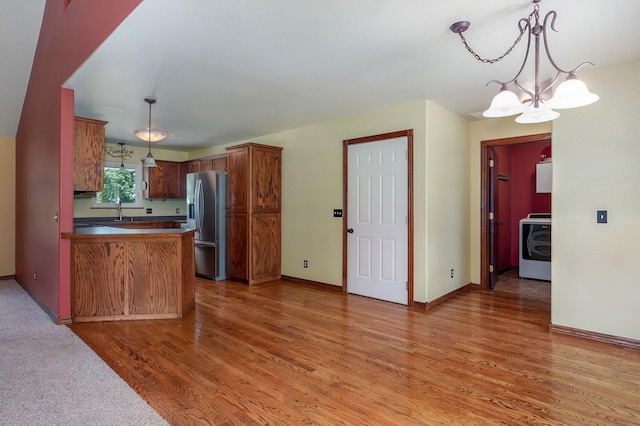 14521 Lawrence Unit 2145, Mount Vernon, MO 65712 - kitchen with washer / dryer, stainless steel refrigerator with ice dispenser, light wood-type flooring, and a chandelier
