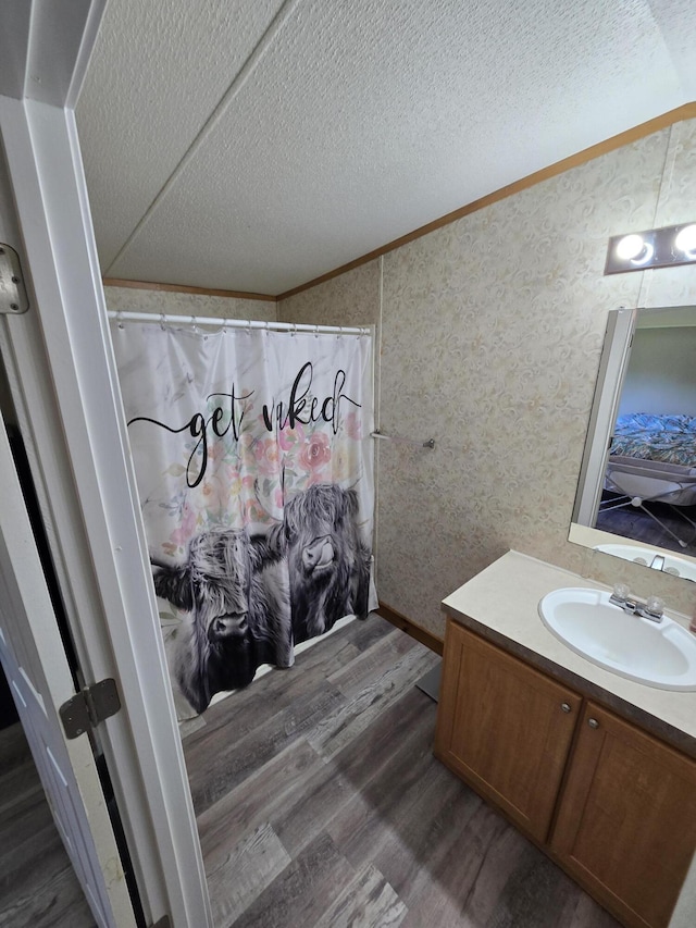 4662 S 30th Rd, Fair Play, MO 65649 - full bath with wallpapered walls, wood finished floors, vanity, a textured ceiling, and ornamental molding