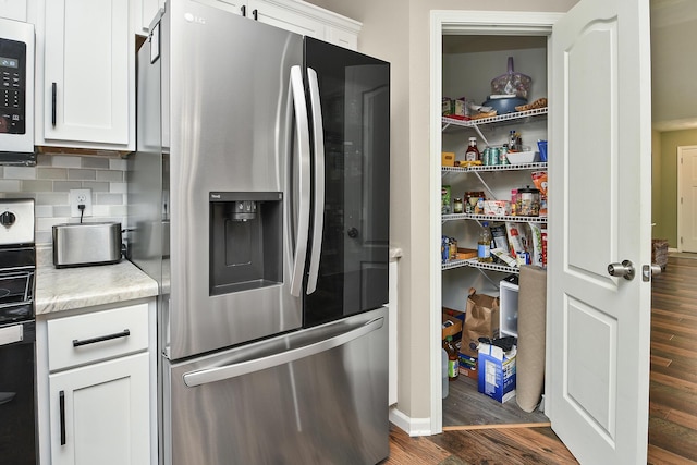 237 Kelsi Ln, Branson, MO 65616 - kitchen with stainless steel refrigerator with ice dispenser, light countertops, dark wood finished floors, white cabinetry, and backsplash
