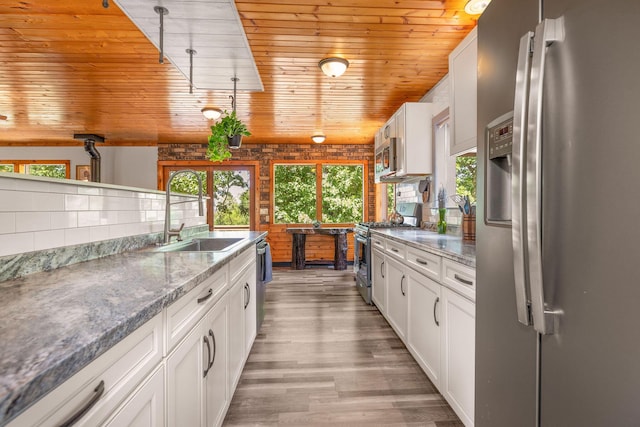 537 Watson Rd, Branson, MO 65616 - kitchen with stainless steel appliances, wooden ceiling, light wood finished floors, white cabinets, and light stone countertops