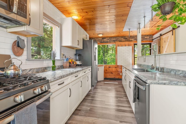 537 Watson Rd, Branson, MO 65616 - kitchen featuring stainless steel appliances, plenty of natural light, white cabinets, a barn door, and wooden ceiling