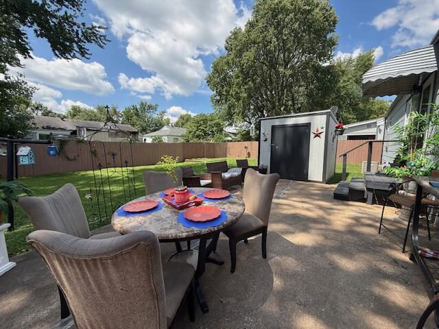 212 W Lindberg St, Springfield, MO 65807 - fenced backyard with a shed, outdoor dining area, and a patio