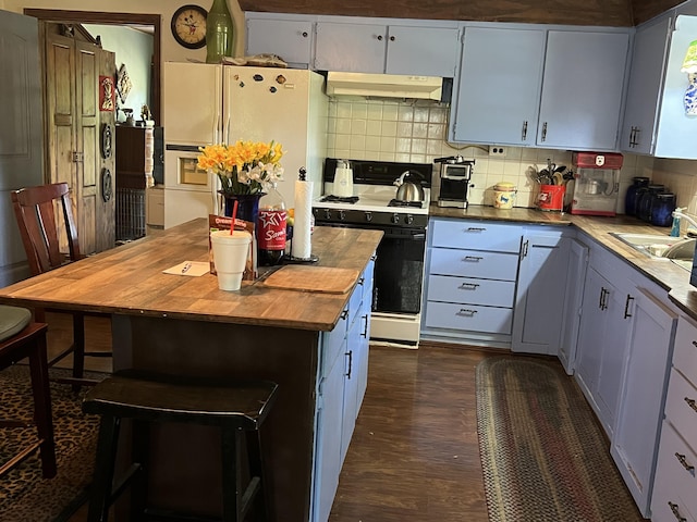 1103 Riverview Dr, Mammoth Spring, AR 72554 - kitchen featuring butcher block counters, white appliances, under cabinet range hood, tasteful backsplash, and dark wood-type flooring