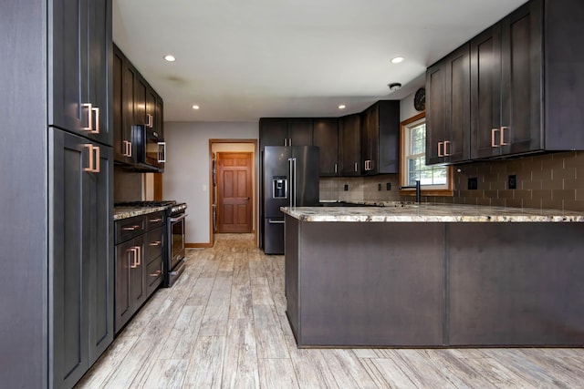 2210 S Catalina Ave, Springfield, MO 65804 - kitchen with high quality fridge, light stone counters, stainless steel gas stove, dark brown cabinets, and a peninsula