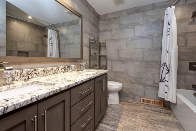 2210 S Catalina Ave, Springfield, MO 65804 - full bath featuring double vanity, shower / tub combo, tile walls, and wood finished floors