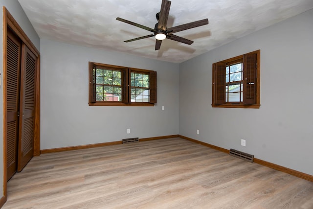 2210 S Catalina Ave, Springfield, MO 65804 - unfurnished bedroom featuring multiple windows, light wood-style flooring, a closet, and ceiling fan