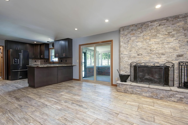 2210 S Catalina Ave, Springfield, MO 65804 - kitchen with high end fridge, open floor plan, light wood-style floors, a stone fireplace, and tasteful backsplash