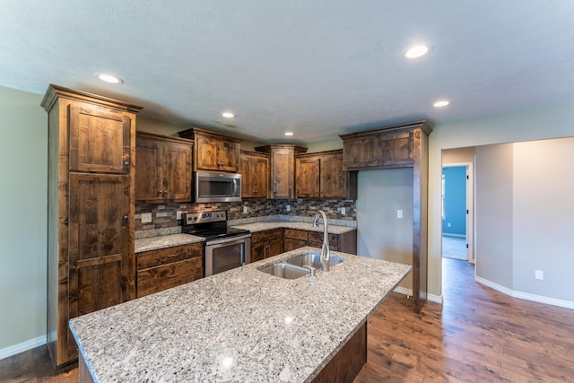 865 E Striper Dr, Nixa, MO 65714 - kitchen featuring appliances with stainless steel finishes, tasteful backsplash, an island with sink, dark wood-type flooring, and recessed lighting