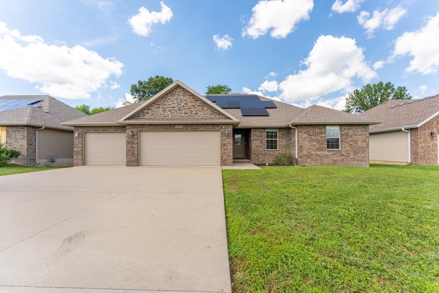 865 E Striper Dr, Nixa, MO 65714 - view of front of property with a garage, roof mounted solar panels, brick siding, and a front lawn