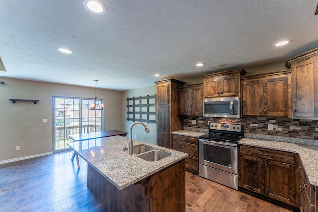 865 E Striper Dr, Nixa, MO 65714 - kitchen with stainless steel appliances, dark wood-style floors, backsplash, a kitchen island with sink, and recessed lighting