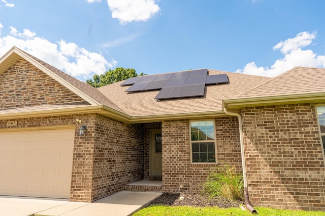 865 E Striper Dr, Nixa, MO 65714 - view of front of house featuring brick siding, solar panels, and a shingled roof