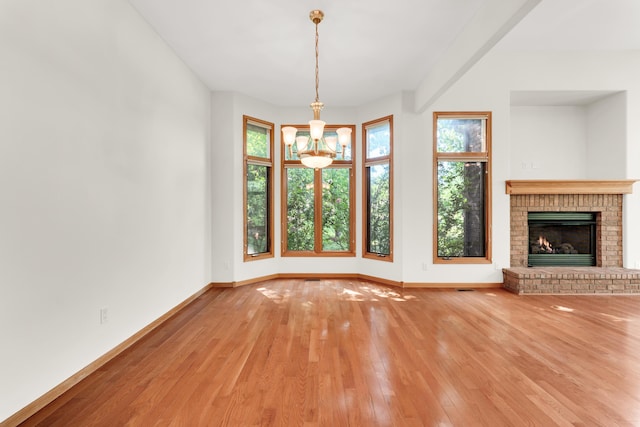 201 Silver Oak Ln, Branson West, MO 65737 - unfurnished living room featuring a chandelier, hardwood / wood-style flooring, and a brick fireplace