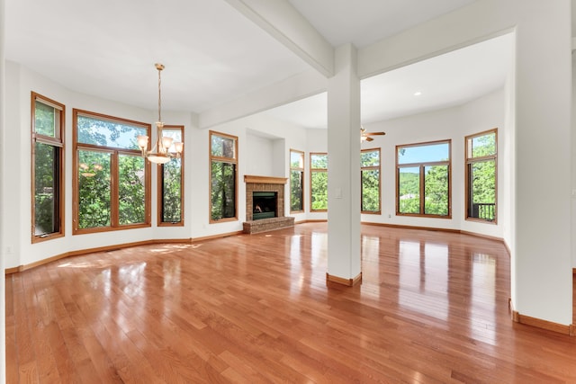201 Silver Oak Ln, Branson West, MO 65737 - unfurnished living room featuring light wood-type flooring, a brick fireplace, and a chandelier