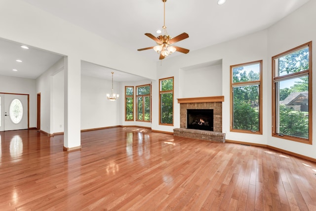 201 Silver Oak Ln, Branson West, MO 65737 - unfurnished living room featuring light wood finished floors, a brick fireplace, a ceiling fan, recessed lighting, and a chandelier