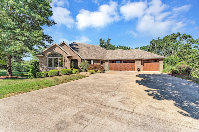 201 Silver Oak Ln, Branson West, MO 65737 - view of front of house featuring brick siding, concrete driveway, a garage, and a front lawn