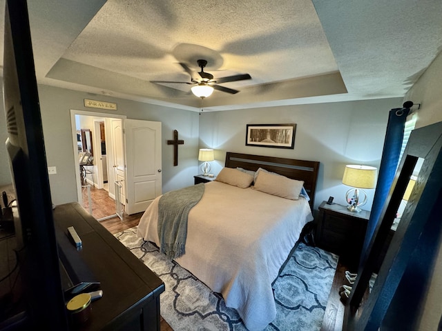 5537 S Pinehurst Ave, Springfield, MO 65810 - bedroom with a textured ceiling, a tray ceiling, ceiling fan, and wood finished floors