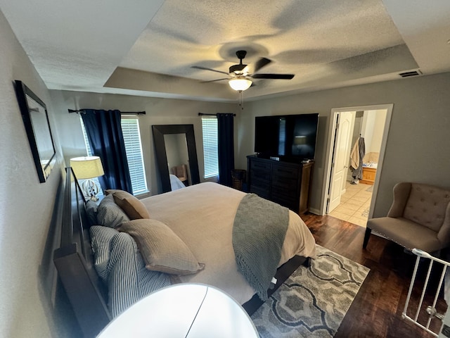 5537 S Pinehurst Ave, Springfield, MO 65810 - bedroom with wood finished floors, a textured ceiling, a raised ceiling, ceiling fan, and ensuite bathroom