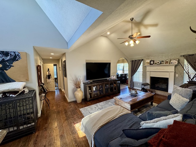 5537 S Pinehurst Ave, Springfield, MO 65810 - living room with wood finished floors, a ceiling fan, a fireplace with raised hearth, a skylight, and high vaulted ceiling