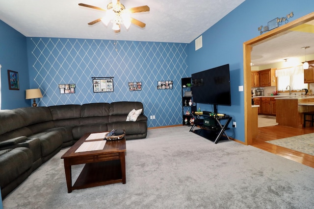 576 S Barnstable, Nixa, MO 65714 - living area featuring an accent wall, a ceiling fan, and light carpet