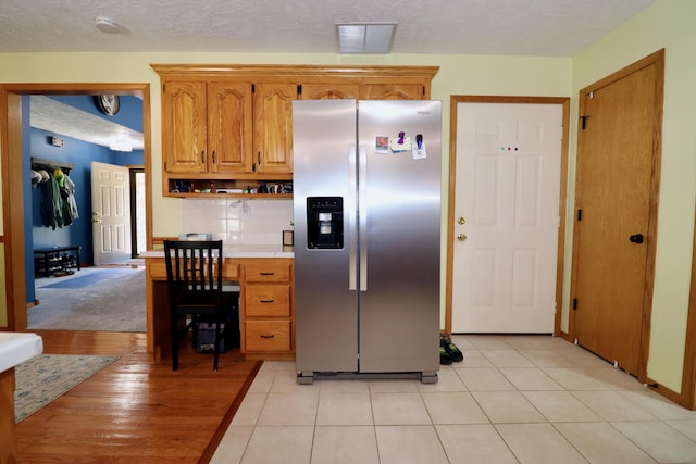 576 S Barnstable, Nixa, MO 65714 - kitchen featuring stainless steel fridge, light countertops, brown cabinets, a textured ceiling, and an office area