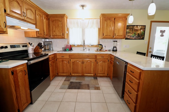 576 S Barnstable, Nixa, MO 65714 - kitchen featuring appliances with stainless steel finishes, a peninsula, under cabinet range hood, and healthy amount of natural light