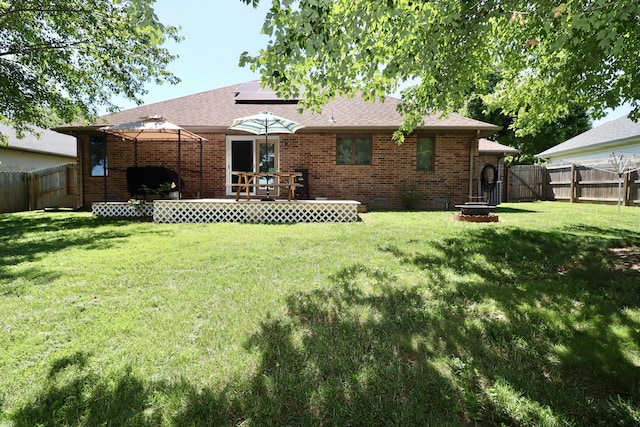 576 S Barnstable, Nixa, MO 65714 - back of house featuring a fenced backyard, roof mounted solar panels, brick siding, and a fire pit