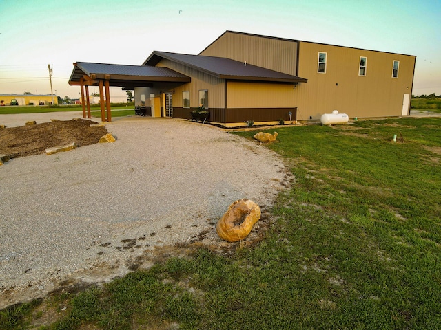 30950 E 54th Hwy, El Dorado Springs, MO 64744 - back of property featuring driveway, a yard, a metal roof, and a carport