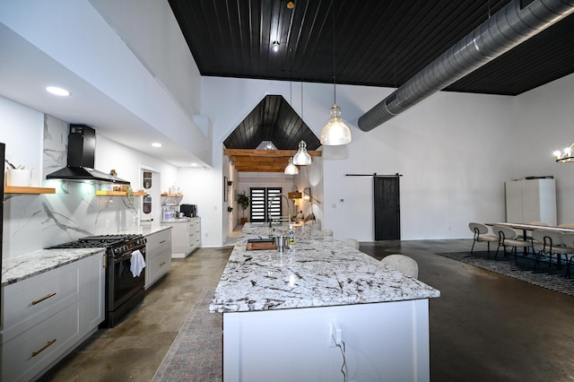30950 E 54th Hwy, El Dorado Springs, MO 64744 - kitchen with black range with gas cooktop, extractor fan, a barn door, concrete floors, and a high ceiling