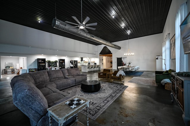30950 E 54th Hwy, El Dorado Springs, MO 64744 - living room with concrete floors, a chandelier, a ceiling fan, and a high ceiling