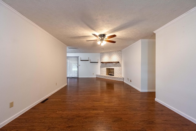 2924 S Roanoke Ave, Springfield, MO 65807 - unfurnished living room featuring ceiling fan, a textured ceiling, crown molding, a brick fireplace, and dark wood-type flooring