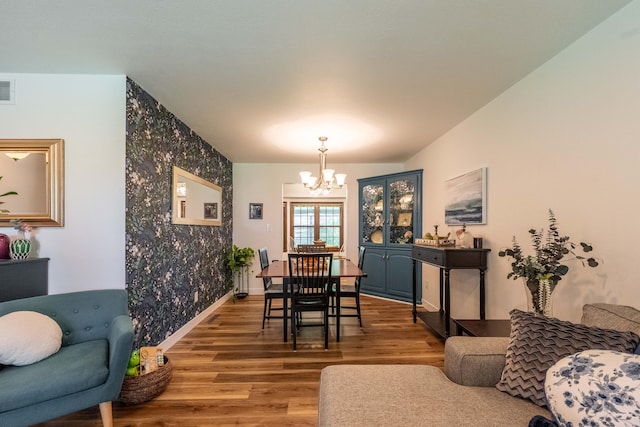 1728 E Camino Alto St, Springfield, MO 65804 - dining space featuring a chandelier, wood finished floors, and an accent wall