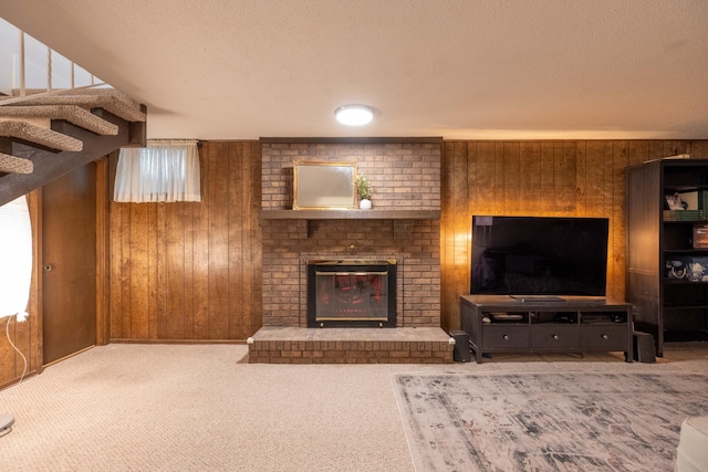 1728 E Camino Alto St, Springfield, MO 65804 - carpeted living room featuring wood walls, a textured ceiling, a brick fireplace, and stairway