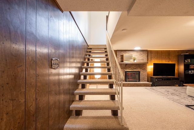 1728 E Camino Alto St, Springfield, MO 65804 - stairs with wooden walls, carpet flooring, and a brick fireplace