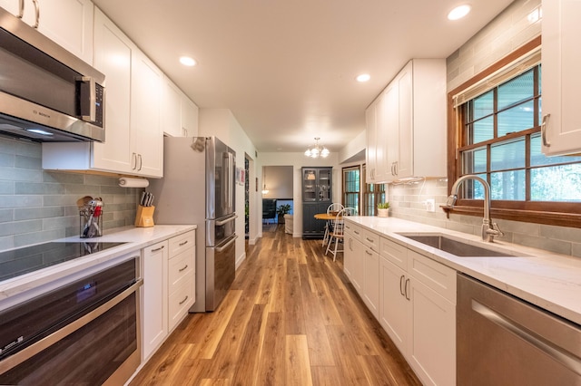 1728 E Camino Alto St, Springfield, MO 65804 - kitchen featuring stainless steel appliances, light wood-style flooring, white cabinetry, tasteful backsplash, and recessed lighting