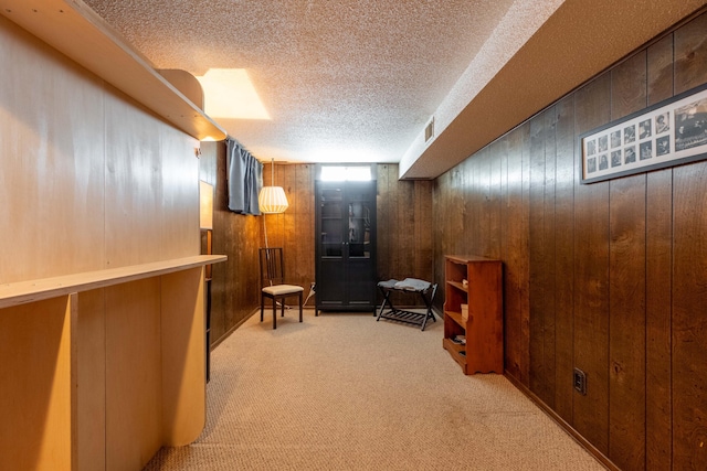 1728 E Camino Alto St, Springfield, MO 65804 - living area featuring wood walls, carpet floors, and a textured ceiling