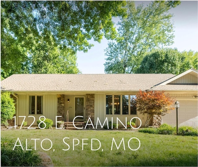 1728 E Camino Alto St, Springfield, MO 65804 - view of front of house with an attached garage, stone siding, a front yard, and roof with shingles