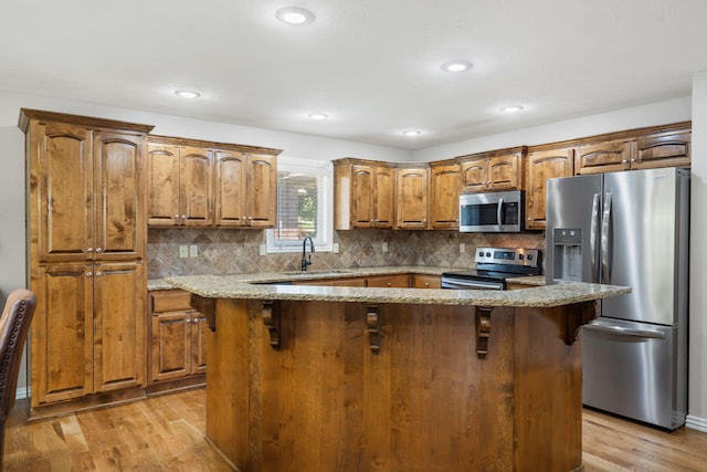1545 N Oakfair Pl, Springfield, MO 65802 - kitchen featuring appliances with stainless steel finishes, light stone counters, light wood-style flooring, decorative backsplash, and recessed lighting